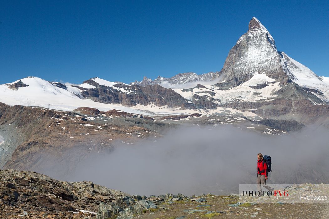 Hiker in the Gornergrat area, towards the Matterhorn or Cervino mount, Zermatt, Valais, Switzerland, Europe