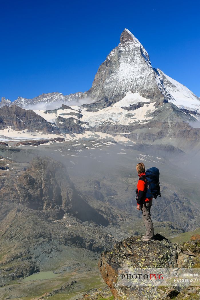 Hiker in the Gornergrat area admiring the Matterhorn or Cervino mount, Zermatt, Valais, Switzerland, Europe