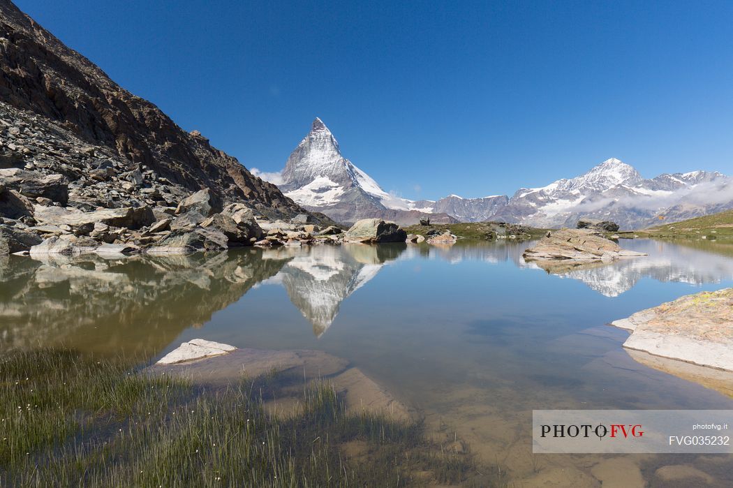 The Matterhorn or Cervino mount reflected in the Riffelsee Lake (Riffel lake), Gornergrat, Zermatt, Valais, Switzerland, Europe
 