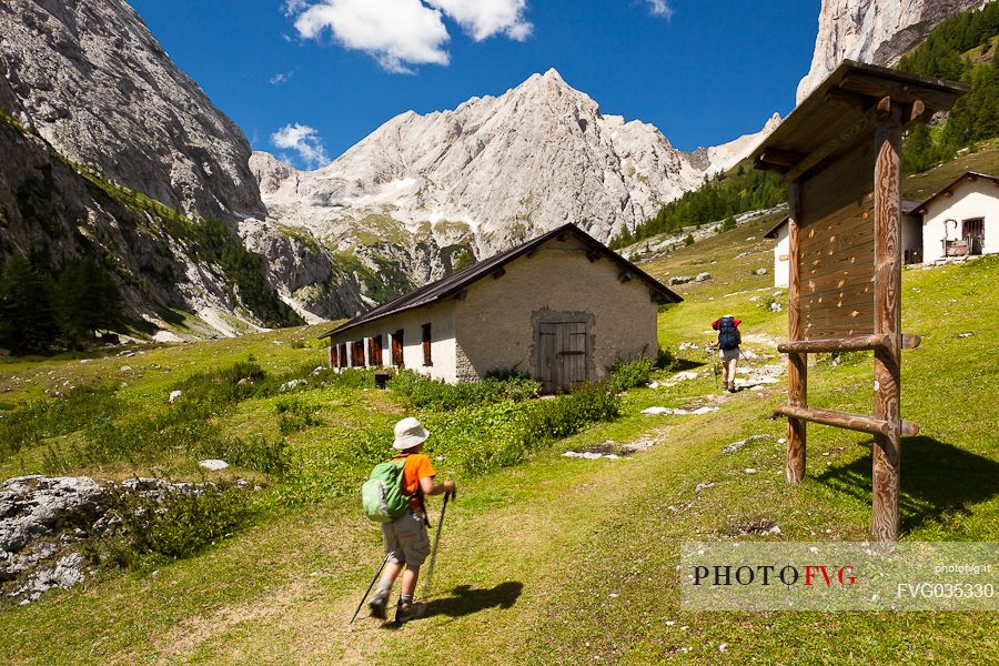 Hiking in the Ombretta valley, in the background the Ombretta peak and the south cliff of Marmolada, Rocca Pietore, dolomites, Veneto, Italy, Europe