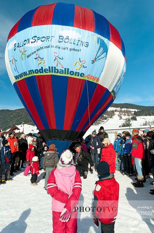 Children admiring the Hot air balloon during the balloons festival in Pusteria valley, Dobbiaco, dolomites, Trentino Alto Adige, Italy, Europe