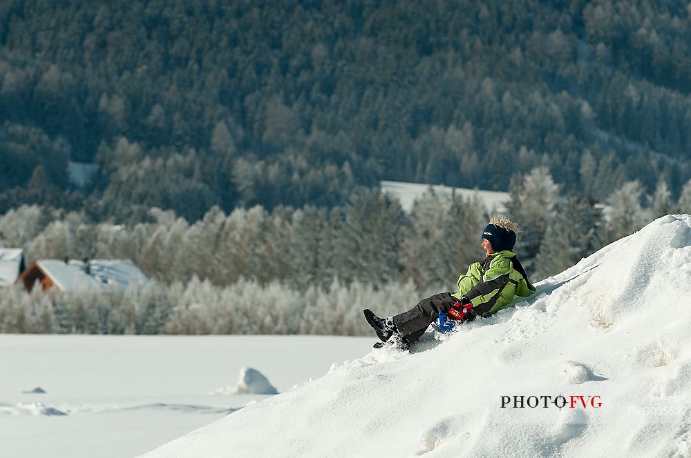 Child has fun on the snow in Fiscalina valley, Sexten, High Pusteria, dolomites, Trentino Alto Adige, Italy, Europe