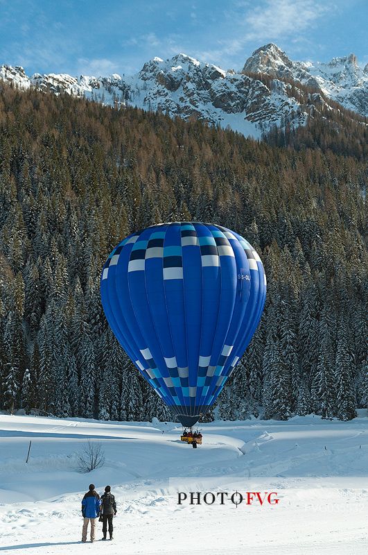 Couple watch the balloon that lands in val Fiscalina during the balloon festival of Dobbiaco, Pusteria valley, dolomites, Trentino Alto Adige, Italy, Europe