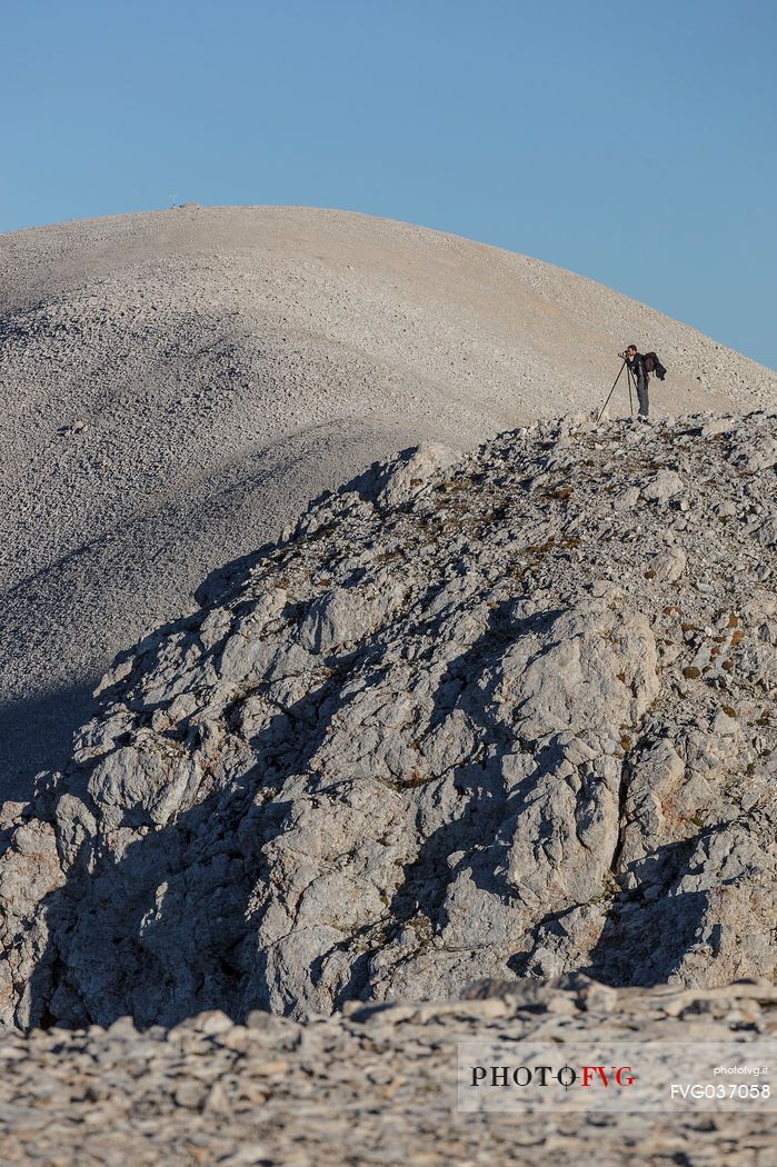 Photographer on the Mount Acquaviva peak in the amphitheater of the Murelle, Majella national park, Abruzzo, Italy, Europe