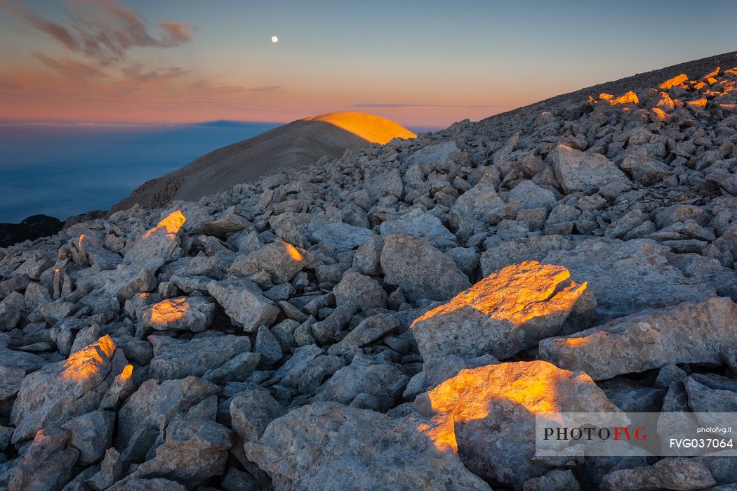 Moon and sunrise at the Mount Acquaviva in the amphitheater of the Murelle, Majella national park, Abruzzo, Italy, Europe