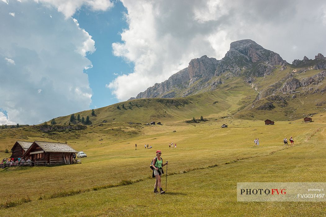 Hikers near Utia Vaciara hut, in the background the Sass de Putia mount, San Martino in Badia, Badia valley, dolomites, South Tyrol, Italy, Europe