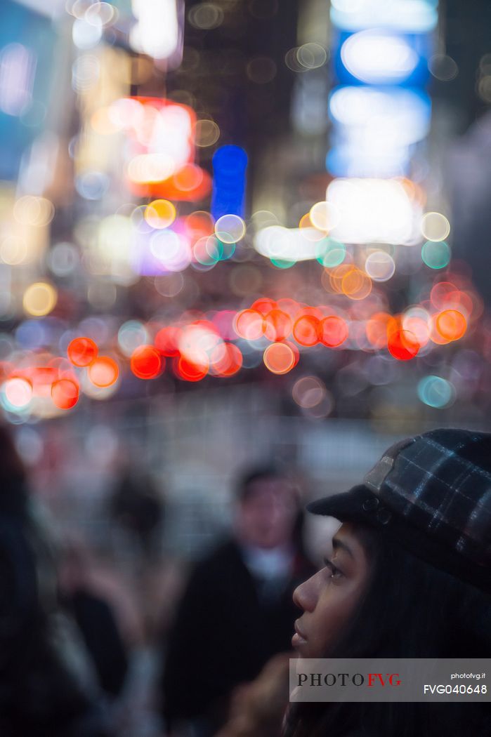 Young woman in Times Square by night, Manhattan, New York, United States