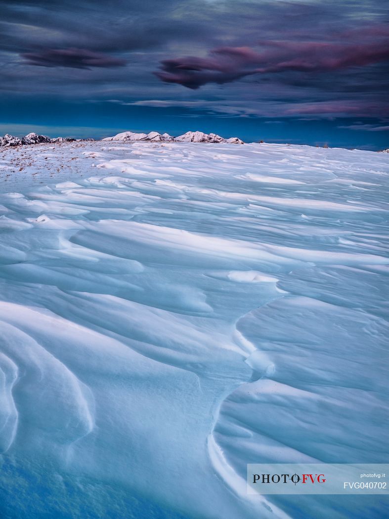 Winter twilight from the top of Pizzoc mount, in the background the peaks of Monte Cavallo mountain range, Cansiglio, Veneto, Italy, Europe