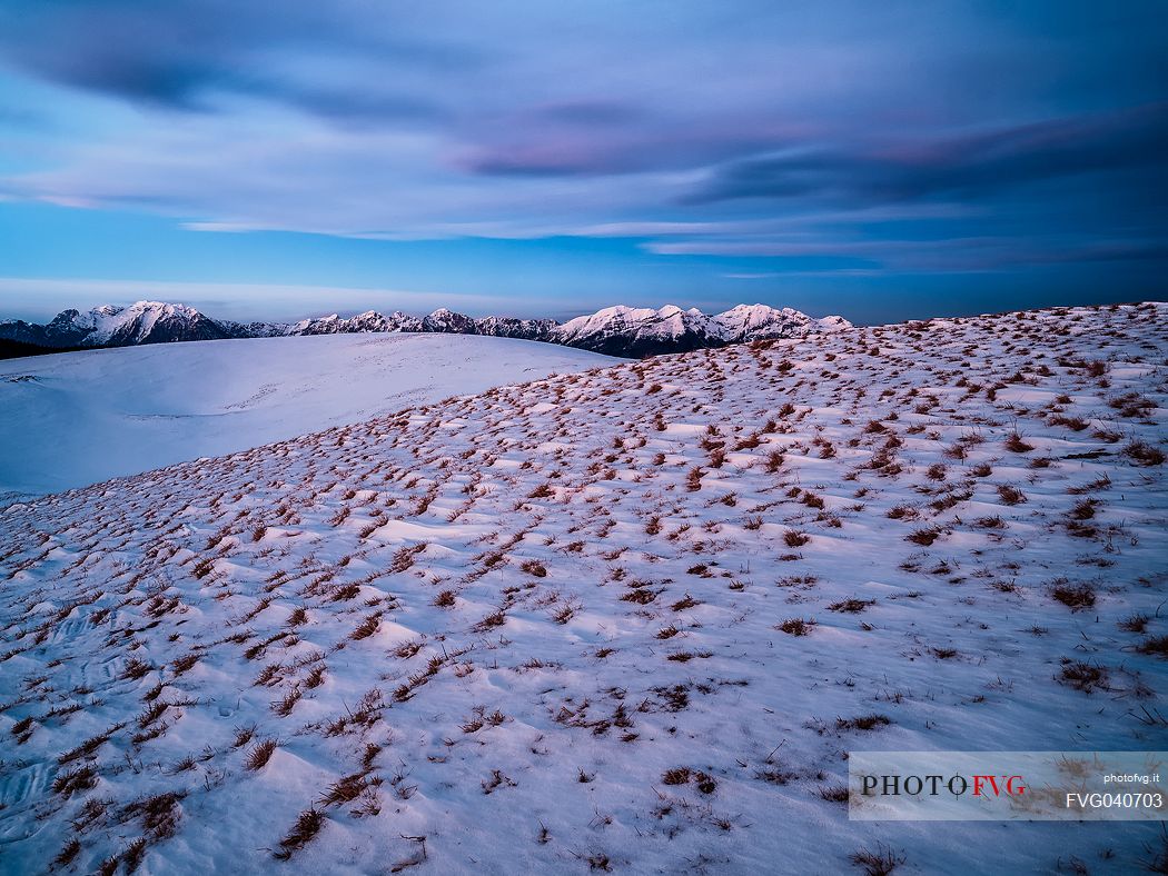 Winter twilight from the top of Pizzoc mount, in the background the peaks of Monte Cavallo mountain range, Cansiglio, Veneto, Italy, Europe