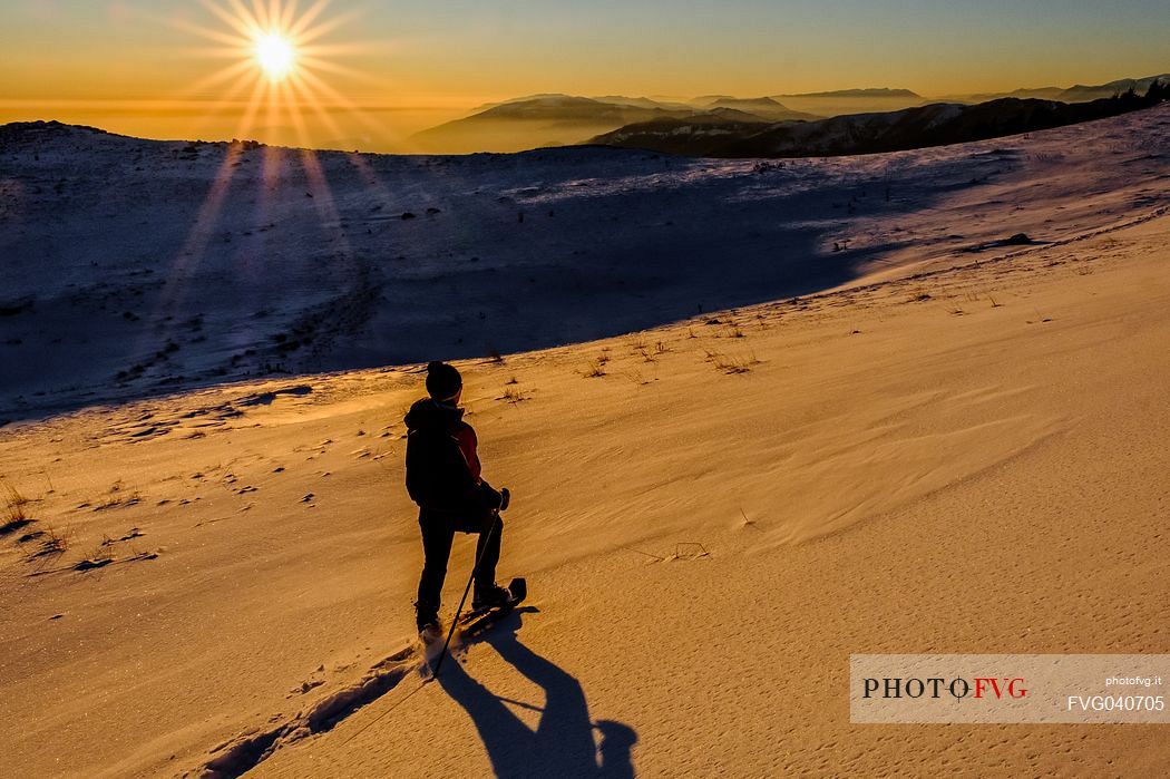 Hiking with snowshoe on the top of Pizzoc mount, Cansiglio plateau, Veneto, Italy, Europe