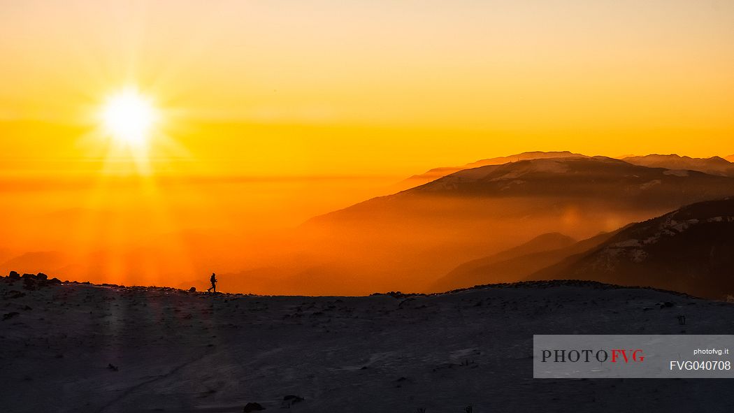 Hiking with snowshoe on the top of Pizzoc mount and in the background the Col Visentin, Cansiglio plateau, Veneto, Italy, Europe