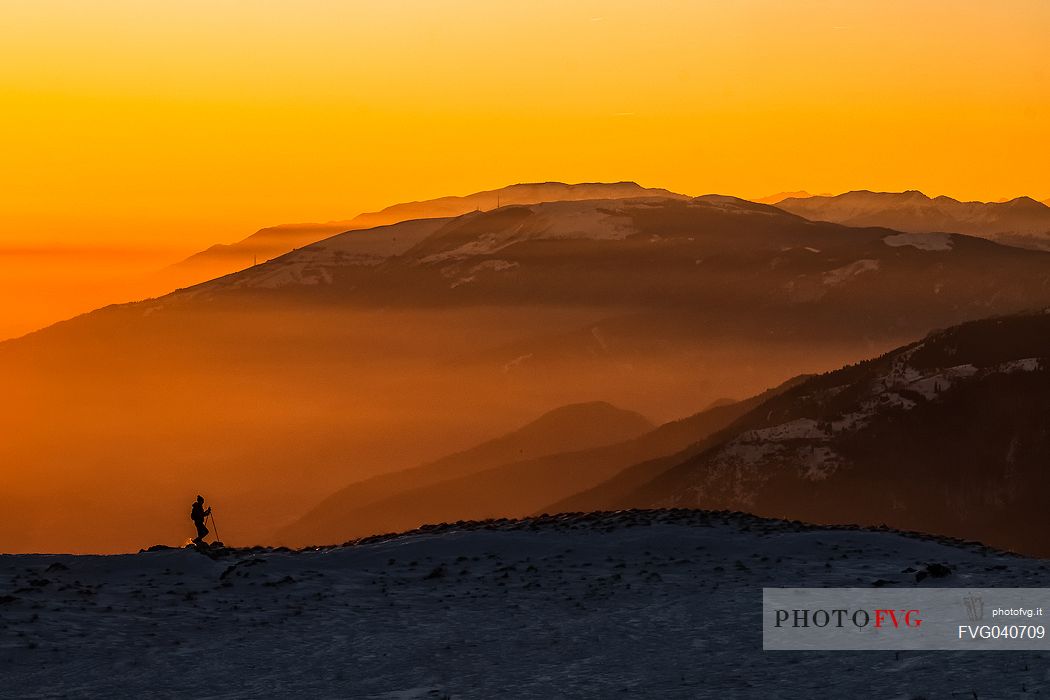 Hiking with snowshoe on the top of Pizzoc mount and in the background the Col Visentin, Cansiglio plateau, Veneto, Italy, Europe