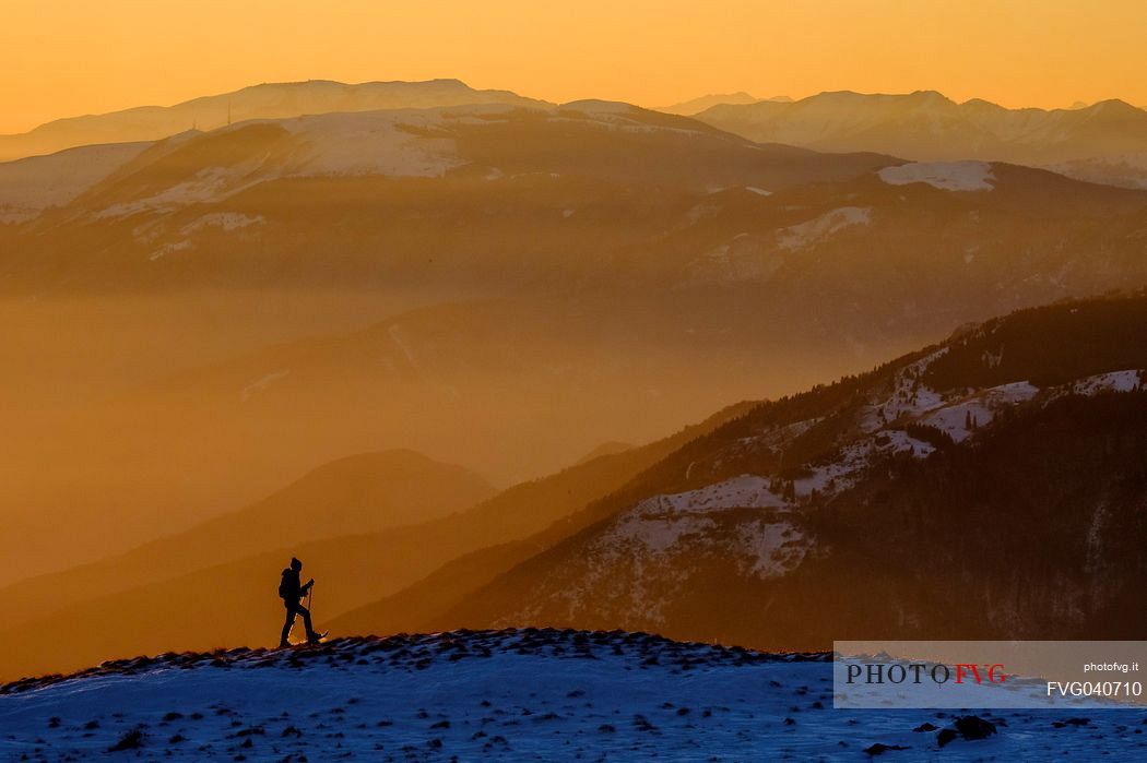 Hiking with snowshoe on the top of Pizzoc mount and in the background the Col Visentin and Montello mounts, Cansiglio plateau, Veneto, Italy, Europe