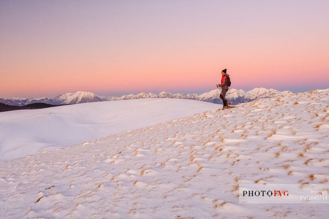 Hiking with snowshoe on the top of Pizzoc mount, in the background the Cavallo mountain range, Cansiglio, Veneto, Italy, Europe