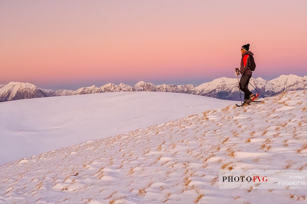 Hiking with snowshoe on the top of Pizzoc mount, in the background the Cavallo mountain range, Cansiglio, Veneto, Italy, Europe