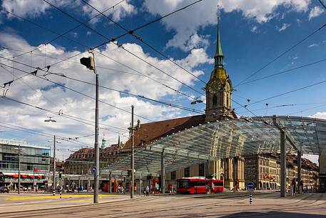 The modern covered tram and train station and in the background Holy Spirit Church or Heiliggeistkirche, Berne, Switzerland, Europe 