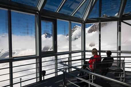 Tourists inside the Sphinx Observatory on top of the Jungfraujoch admiring the Aletsch glacier, the largest in Europe, Bernese alps, Switzerland, Europe