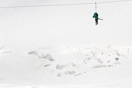 Fun on Aletsch glacier, floating on the steel cable over crevasses, Jungfraujoch, Berner Oberland, Switzerland, Europe Fun on Aletsch glacier, floating on the steel cable over crevasses, Jungfraujoch, Berner Oberland, Switzerland, Europe