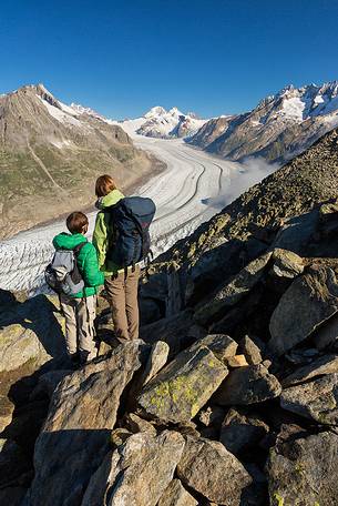 Mother and son at the Eggishorn mountain admiring the Aletsch glacier and Jungfrau mountains, Valais, Switzerland, Europe