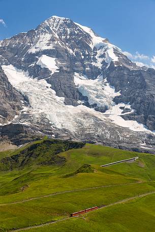 Typical swiss red train on Kleine Scheidegg, Jungfraujoch Railway, mountain pass between Eiger and Lauberhorn peaks, Grindelwald, Switzerland, Europe Typical swiss red train on Kleine Scheidegg, Jungfraujoch Railway, mountain pass between Eiger and Lauberhorn peaks, Grindelwald, Switzerland, Europe