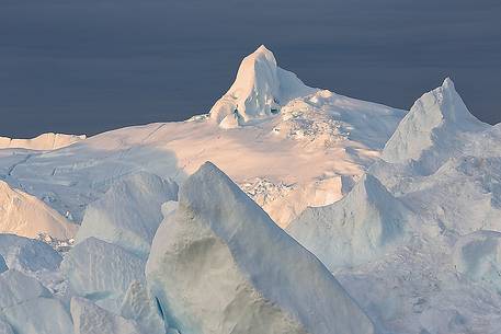 Morning light on icebergs of Kangerlua Fjord at dawn