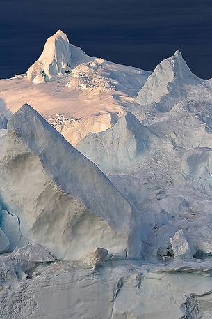 Morning light on icebergs of Kangerlua Fjord at dawn