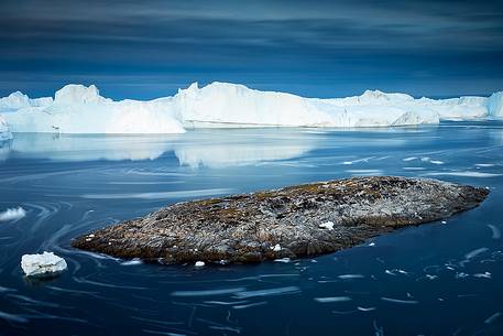 Moving ice in the water of Illulissat Fjord with the first morning light Moving ice in the water of Illulissat Fjord with the first morning light