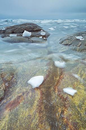 The reefs near the church of Illulissat town: in the background the moving ice of Illulissat Fjord