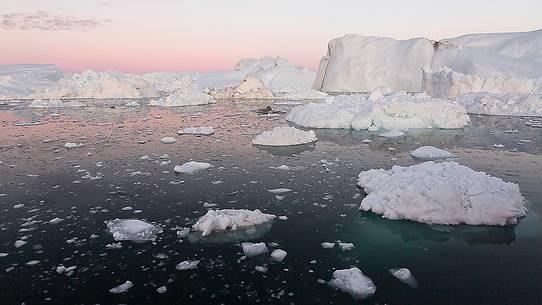 Moonlight over the icebergs of Kangerlua Fjord at dusk