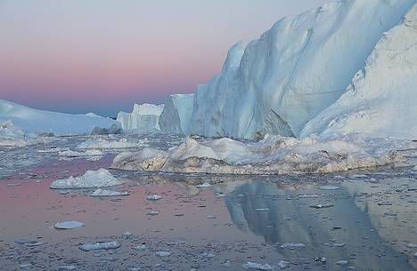 Moonlight over the icebergs of Kangerlua Fjord at dusk