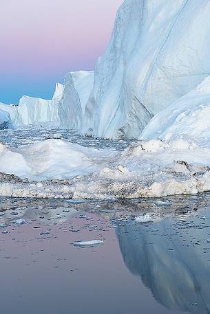 Moonlight over the icebergs of Kangerlua Fjord at dusk