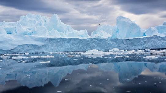 Dark clouds above blue icebergs in Disko Bay