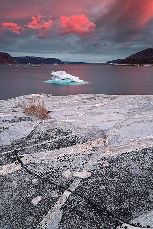 Pink clouds above iceberg in the sea in front  of Ataa a small village of
fishermen and seal hunters which was abandoned in the 50s