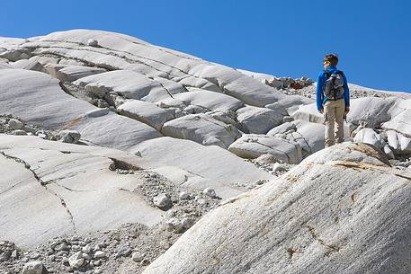 Boy walks in the moraine of the Rhone glacier, Furka pass, Valais, Switzerland, Europe