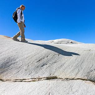 Tourist walks in the rocks of the Rhone glacier, Furka pass, Valais, Switzerland, Europe Tourist walks in the rocks of the Rhone glacier, Furka pass, Valais, Switzerland, Europe