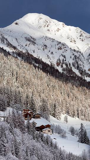 Typical mountain houses near Colle di Santa Lucia after an intense snowfall Typical mountain houses near Colle di Santa Lucia after an intense snowfall
