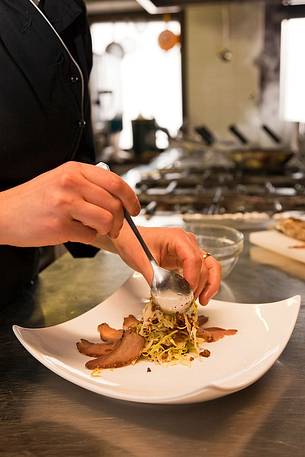 Chef working in the kitchen of Morgenleit restaurant, Sauris