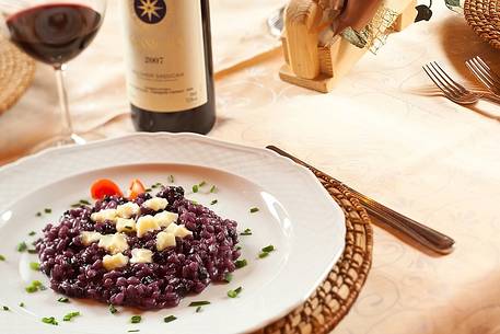 Orzotto with blueberries and alpine cheese, a typical plate of the restraunt Morgenleit in Sauris