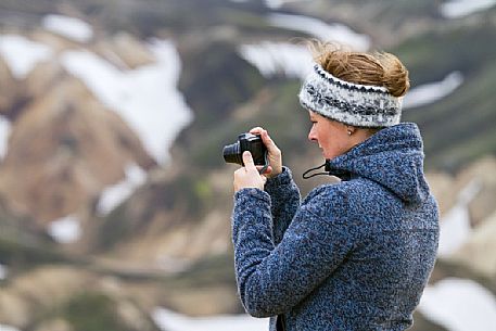 Young girl takes photos in the multicoloured rhyolite mountain area of Landmannalaugar