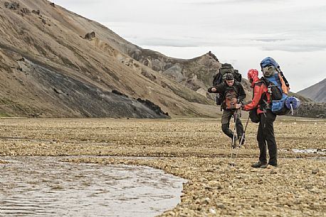 Young people hiking in multicoloured rhyolite mountain area of Landmannalaugar