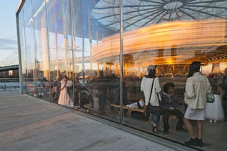 Young girl admiring  the Brooklyn bridge and Manhattan skyline at sunrise