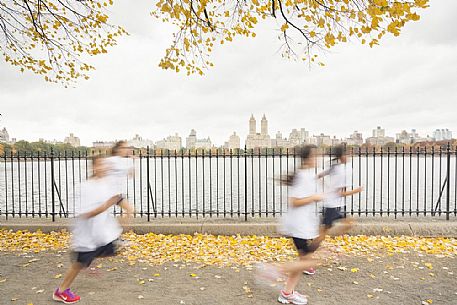Students running by the Jaqueline Kennedy Onassis Reservoir with El Dorado Apartments building in the background
