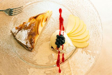 Apple pie with vanilla ice cream, blueberries and raspberry sauce, restaurant alla Pace of Sauris