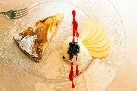 Apple pie with vanilla ice cream, blueberries and raspberry sauce, restaurant alla Pace of Sauris Apple pie with vanilla ice cream, blueberries and raspberry sauce, restaurant alla Pace of Sauris
