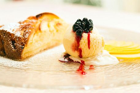 Apple pie with vanilla ice cream, blueberries and raspberry sauce, restaurant alla Pace of Sauris