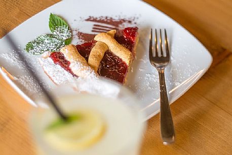 Elderberry juice and tart with raspberry jam in Malga Rinfreddo, Comelico, dolomites, Italy