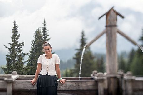 Smiling girl with a traditional dress at Rinfreddo hut, Comelico, dolomites, Italy