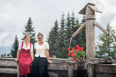 Smiling girls with a traditional dress at Rinfreddo hut, Comelico, dolomites, Italy Smiling girls with a traditional dress at Rinfreddo hut, Comelico, dolomites, Italy