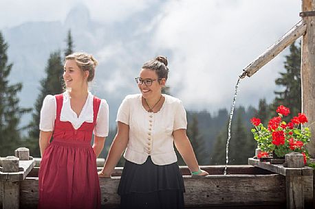 Smiling girls with a traditional dress at Rinfreddo hut, Comelico, dolomites, Italy Smiling girls with a traditional dress at Rinfreddo hut, Comelico, dolomites, Italy