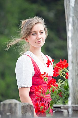 Smiling girl wearing traditional costume at Rinfreddo hut, Comelico, dolomites, Italy